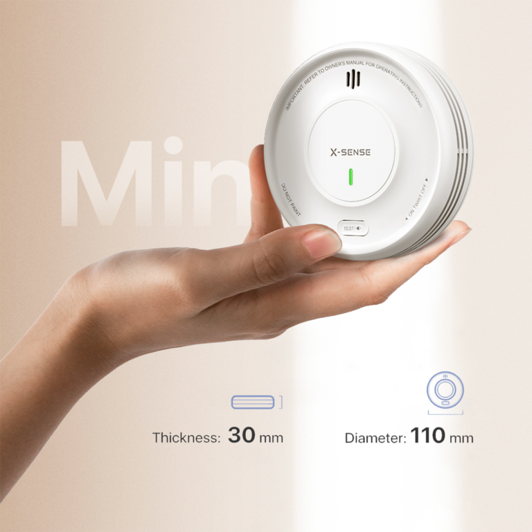 En hand som håller en vit rökvarnare XS0D-MR visar dess storlek